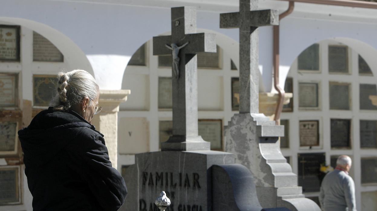 Una mujer frente a una tumba en el cementerio de San Rafael