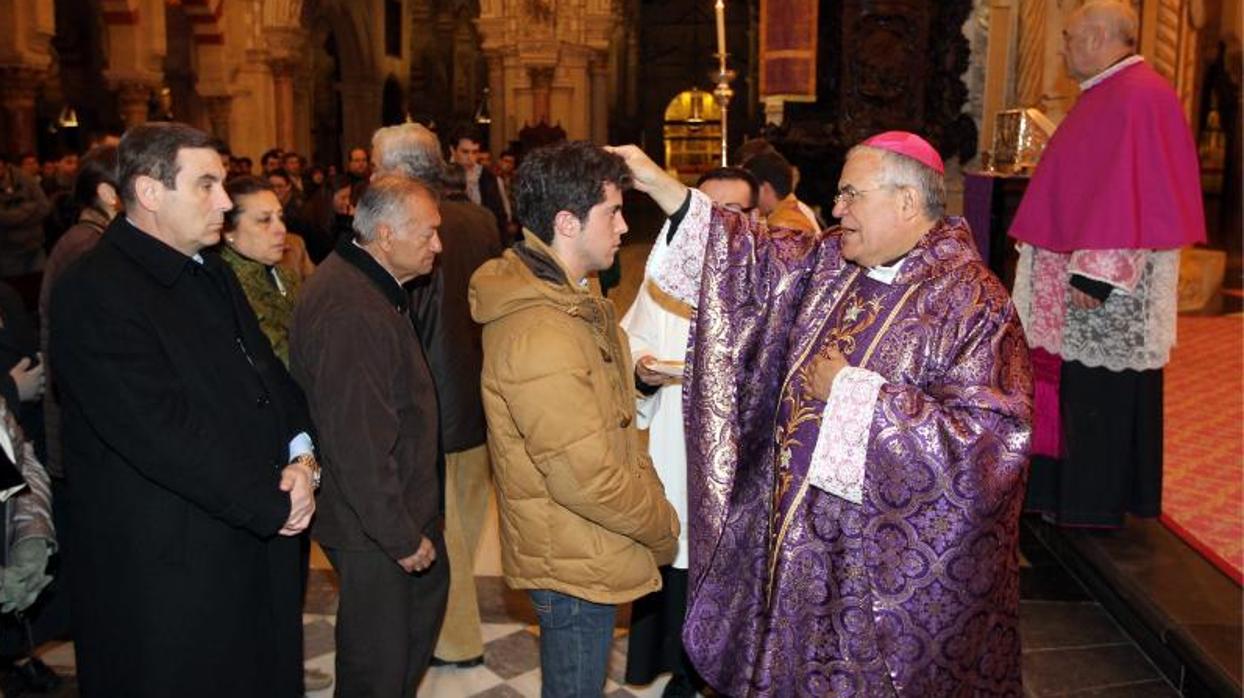 El Obispo de Córdoba imponiendo la Ceniza, con el presidente de la Agrupación de Cofradías en cola