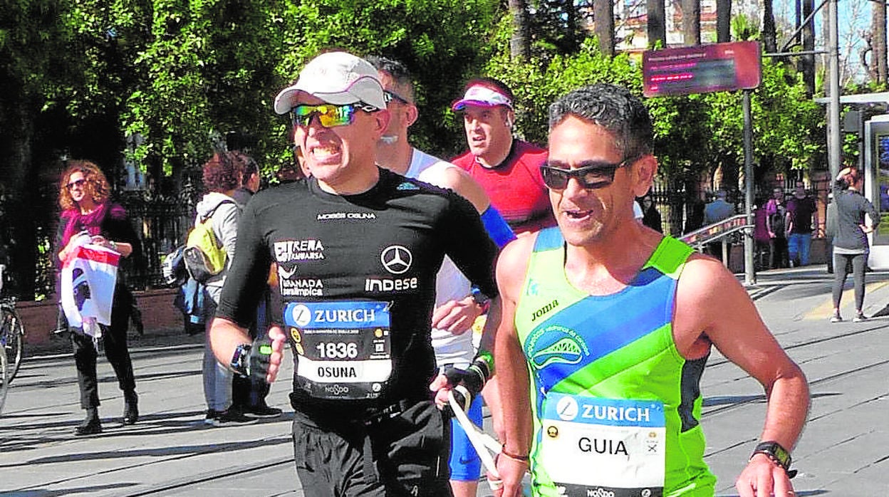 Joaquín de la Vega, a la derecha, guiando al atleta paralímpico Moisés Osuna en la última Maratón de Sevilla