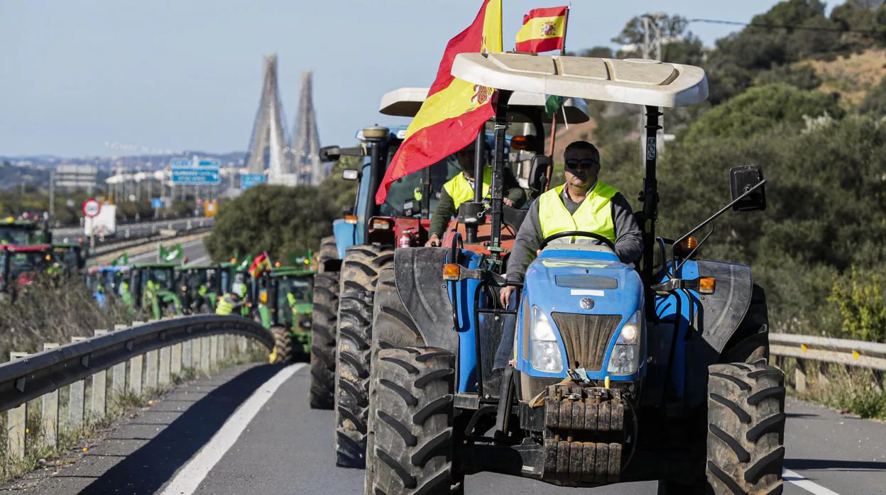 Tractores cortando la autovía en Ayamonte, con el puente internacional a Portugal al fondo