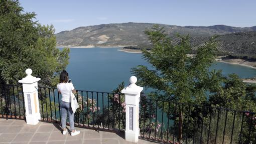 Una turistas fotografía el lago de Iznájar