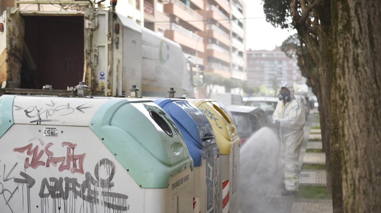 Un operario desinfecta contenedores de basura