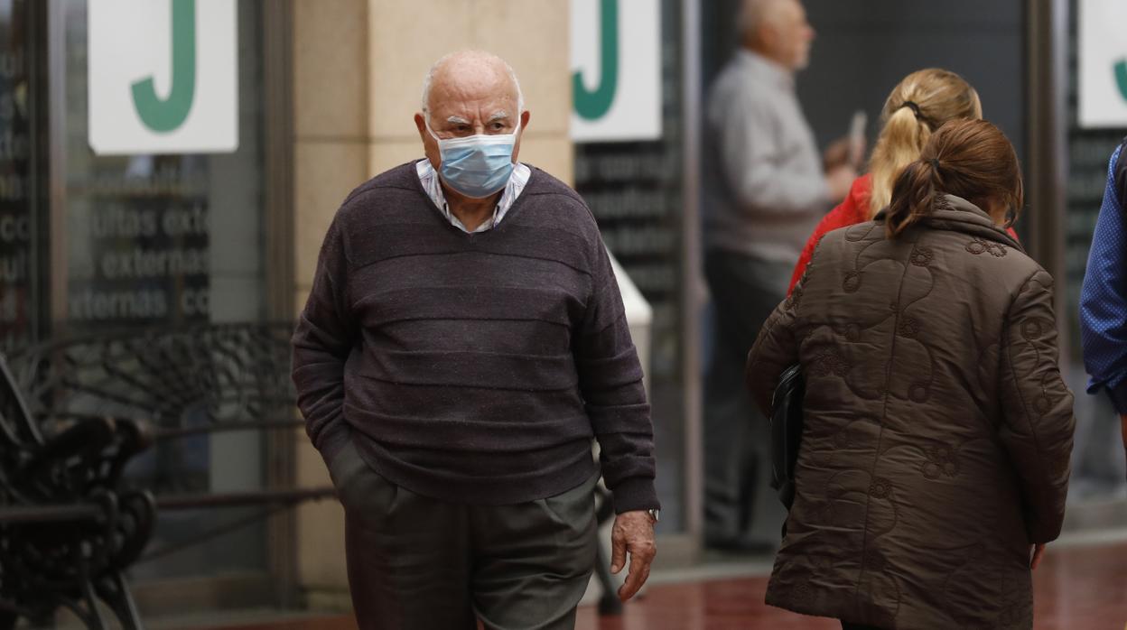 Una persona mayor saliendo de un centro sanitario