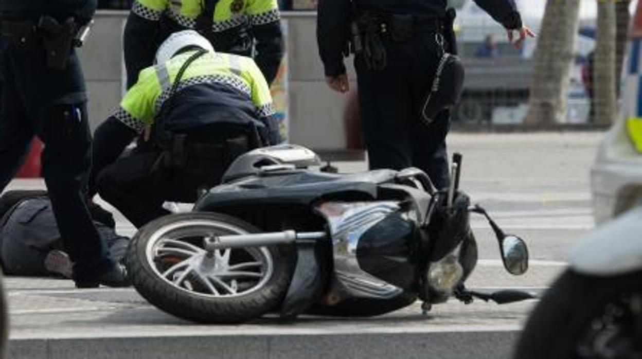 Policias locales atienden a un motorista herido en un accidente de tráfico urbano