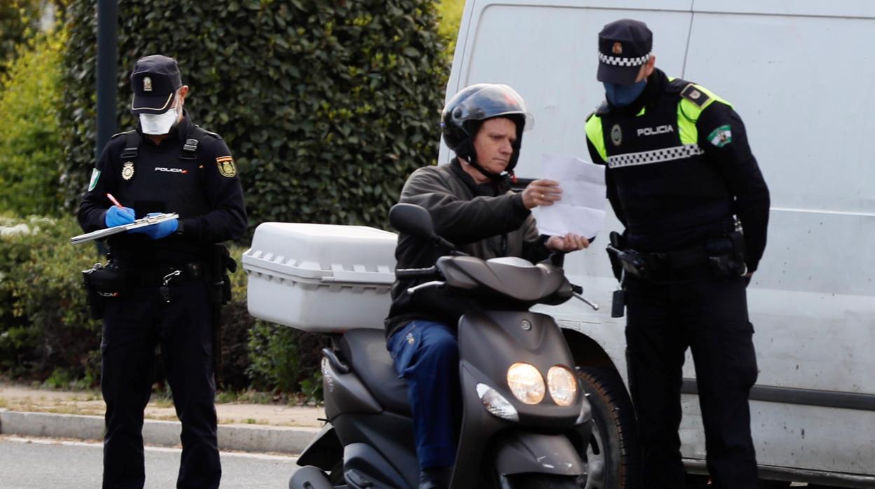 Un policia local comprueba la documentación junto a uno nacional