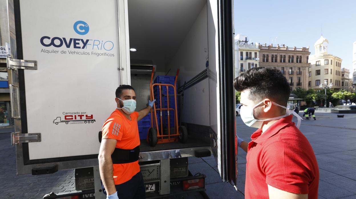 Dos trabajadores con mascarilla y en mangas de camisa