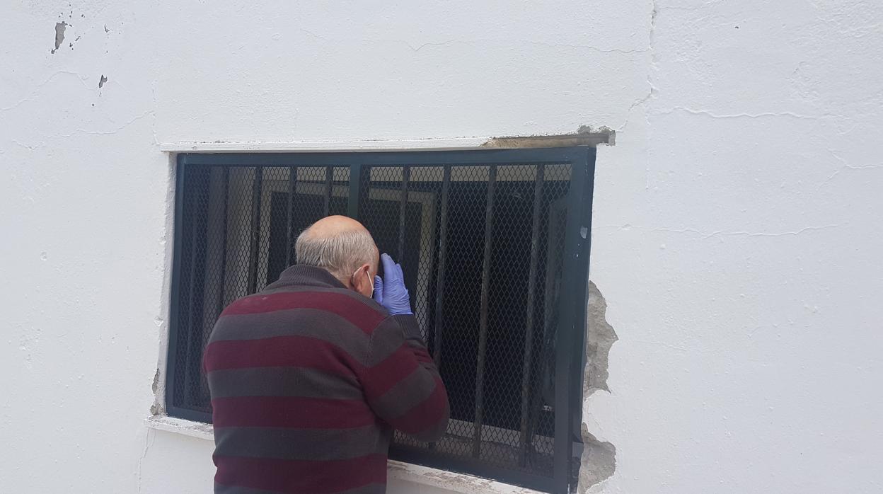 Un vecino observa la sala en la que se produjo el robo de Cáritas de Aguilar