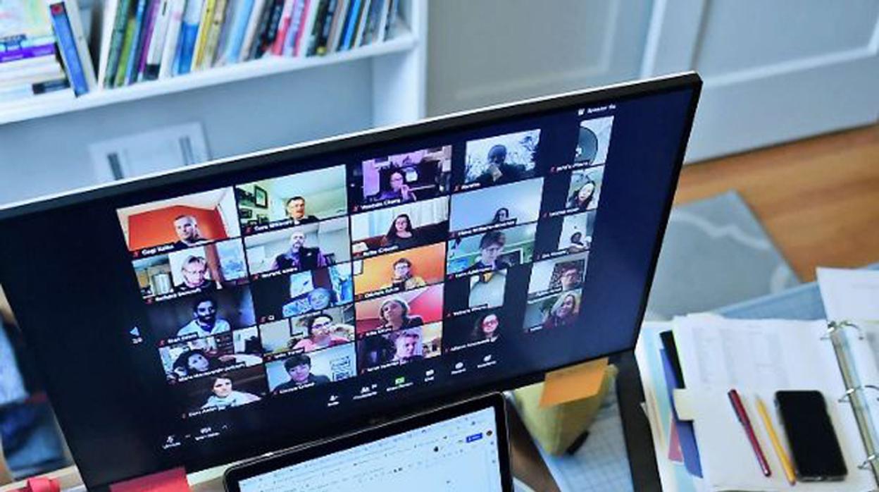 Una mujer usa videoconferencia en su mesa de trabajo