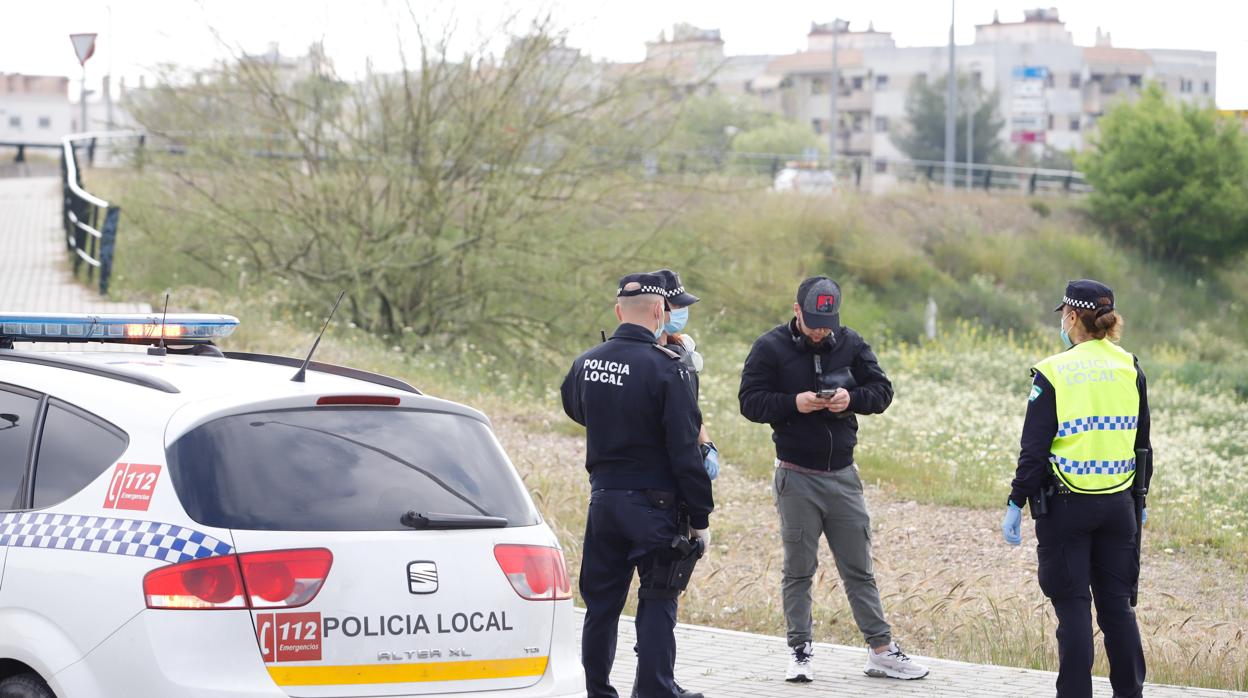 Dos agentes de la Policía Local junto a un viandante durante el Covid-19