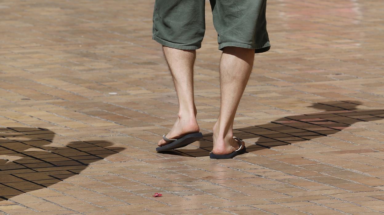 Un hombre camina con calzado ligero por el centro de Córdoba