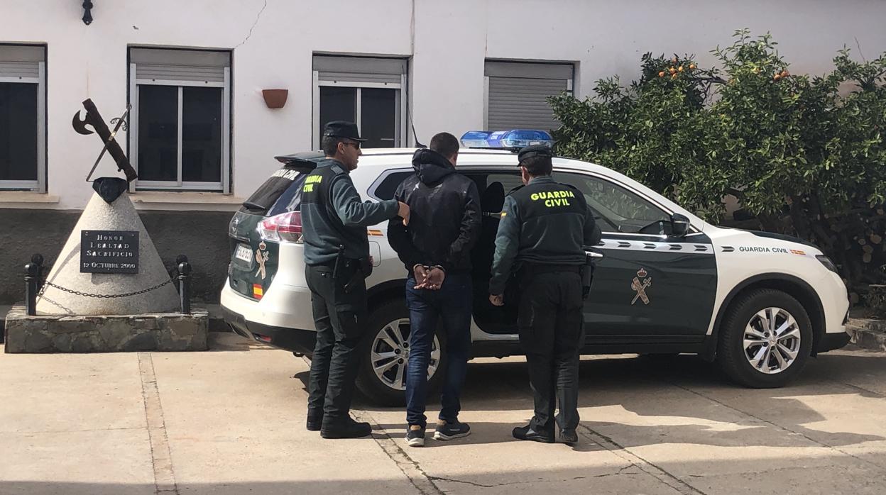 Agentes de la Guardia Civil custodian a uno de los tres detenidos en Vilches