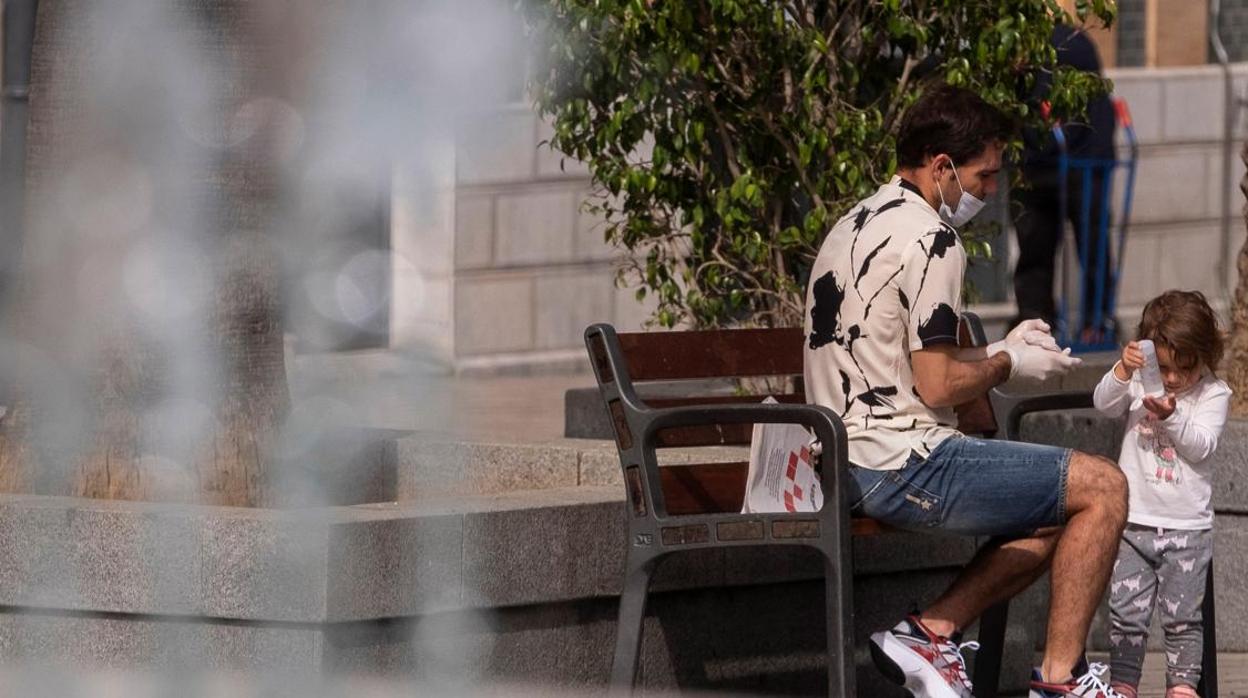 Un padre y su hija en una plaza de Huelva