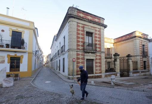 Un joven pasea a su perro delante del inmueble