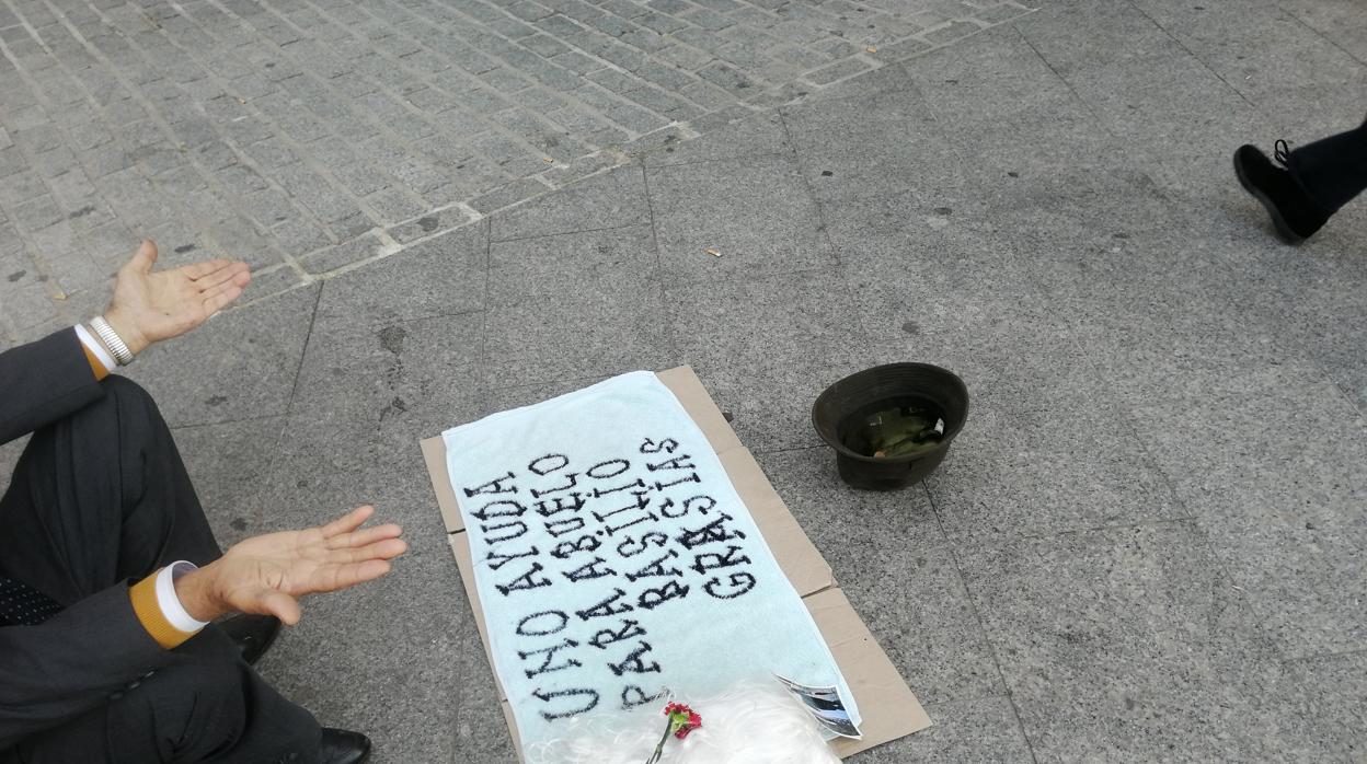 Un mendigo pide ayuda en una de las principales calles de Jaén