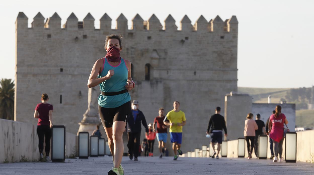 Una mujer practica deporte por el Puente Romano de Córdoba