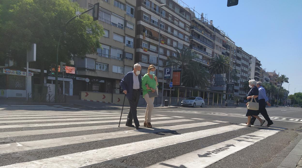 Dos personas cruzan el Paseo de la Victoria de Córdoba