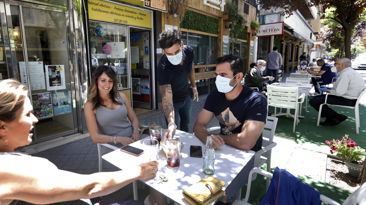 Un grupo de jóvenes se toman unos refrescos en un velador