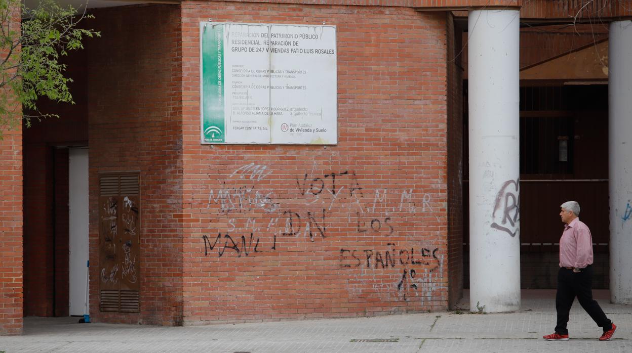 Un hombre pasa delante del patio Luis Rosales de Moreras, uno de los barrios más pobres de España