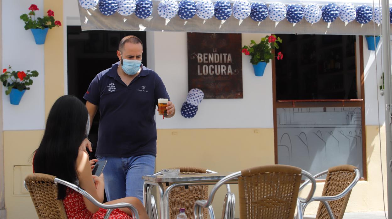 Un camarero del bar Bendita Locura de Córdoba atiende a una clienta