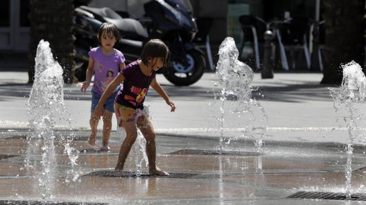 Dos niños se refrescan en una fuente de Córdoba durante el último verano