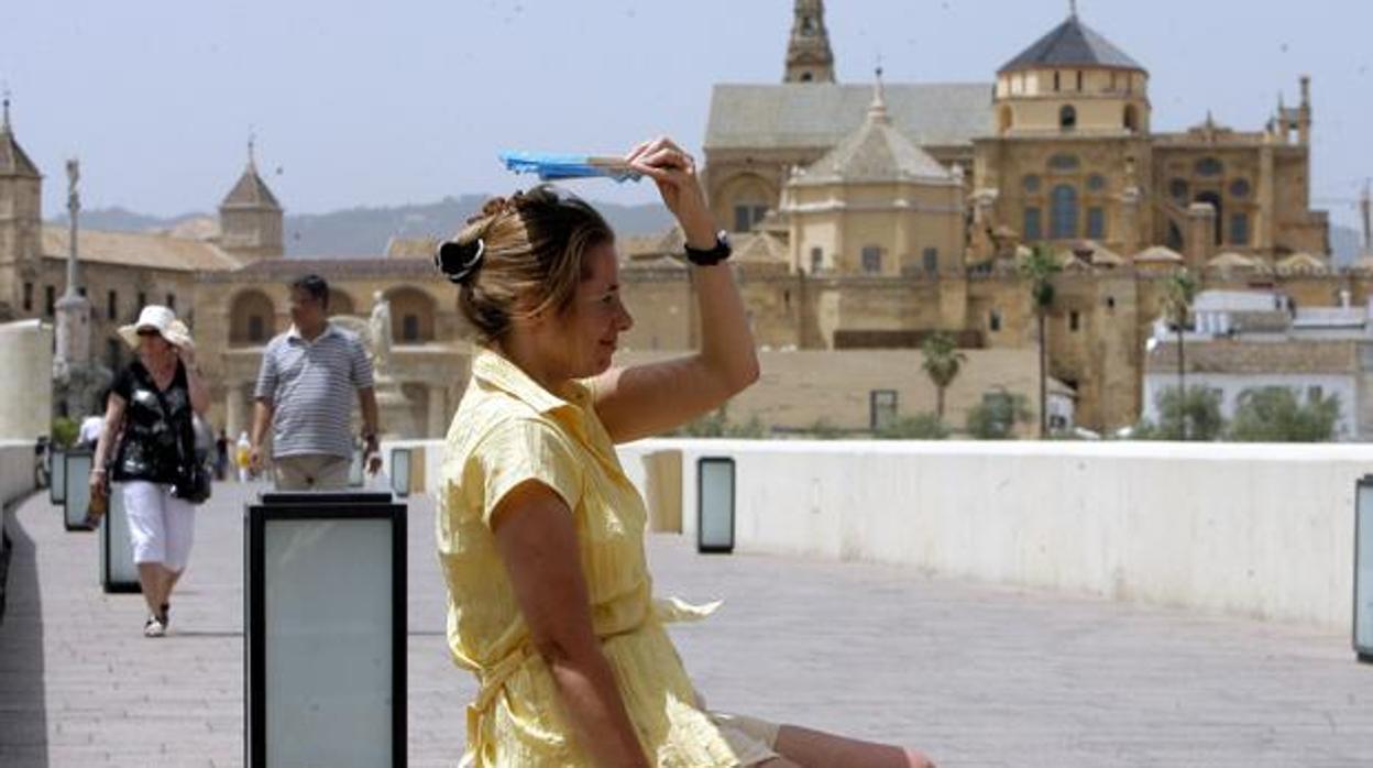 Una joven protegiéndose del calor en una foto de archivo