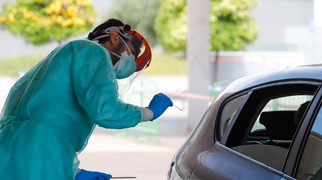 Un sanitario se dispone a realizar un test de coronavirus a un conductor en Sevilla