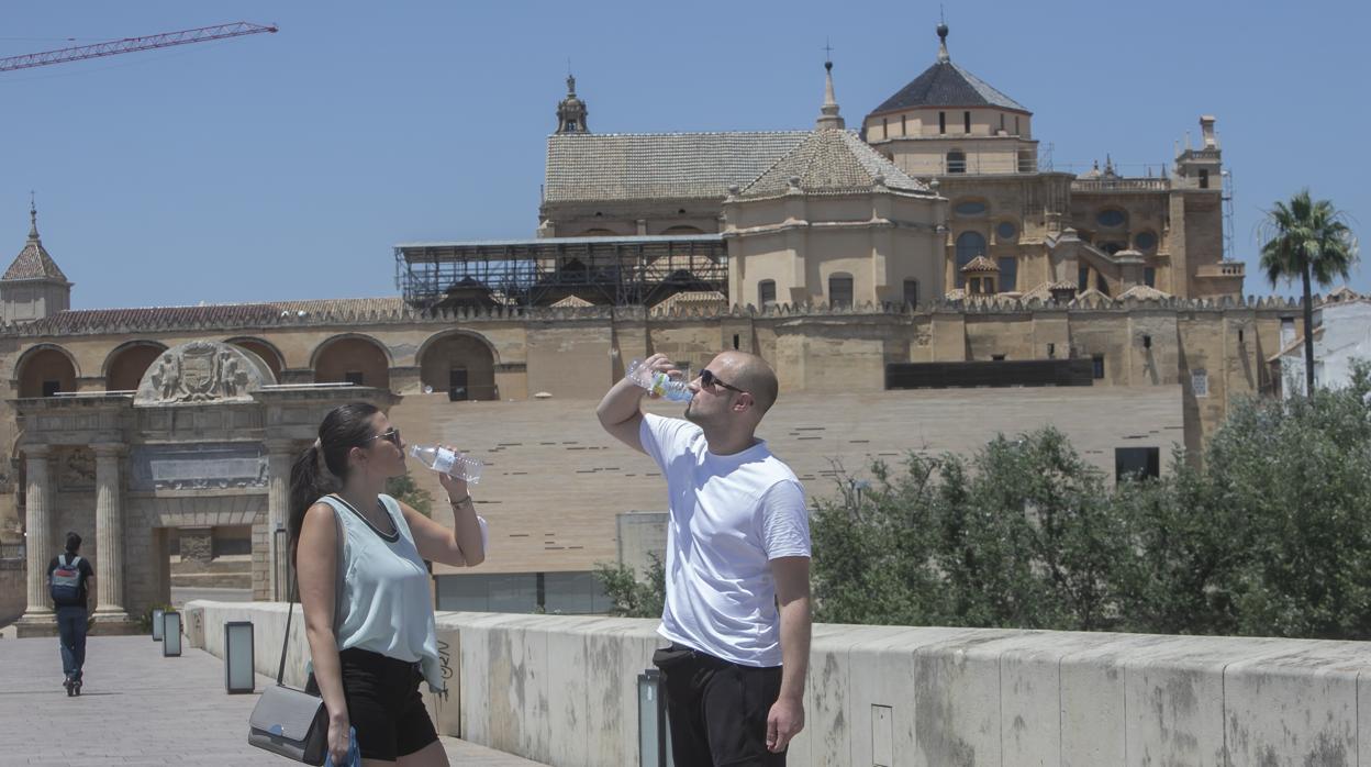 Dos personas se refrescan en el Puente Romano este junio en Córdoba