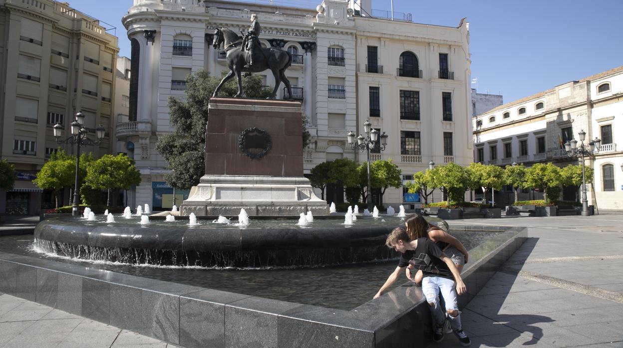 Dos jóvenes se refrescan en la plaza de Las Tendillas de Córdoba