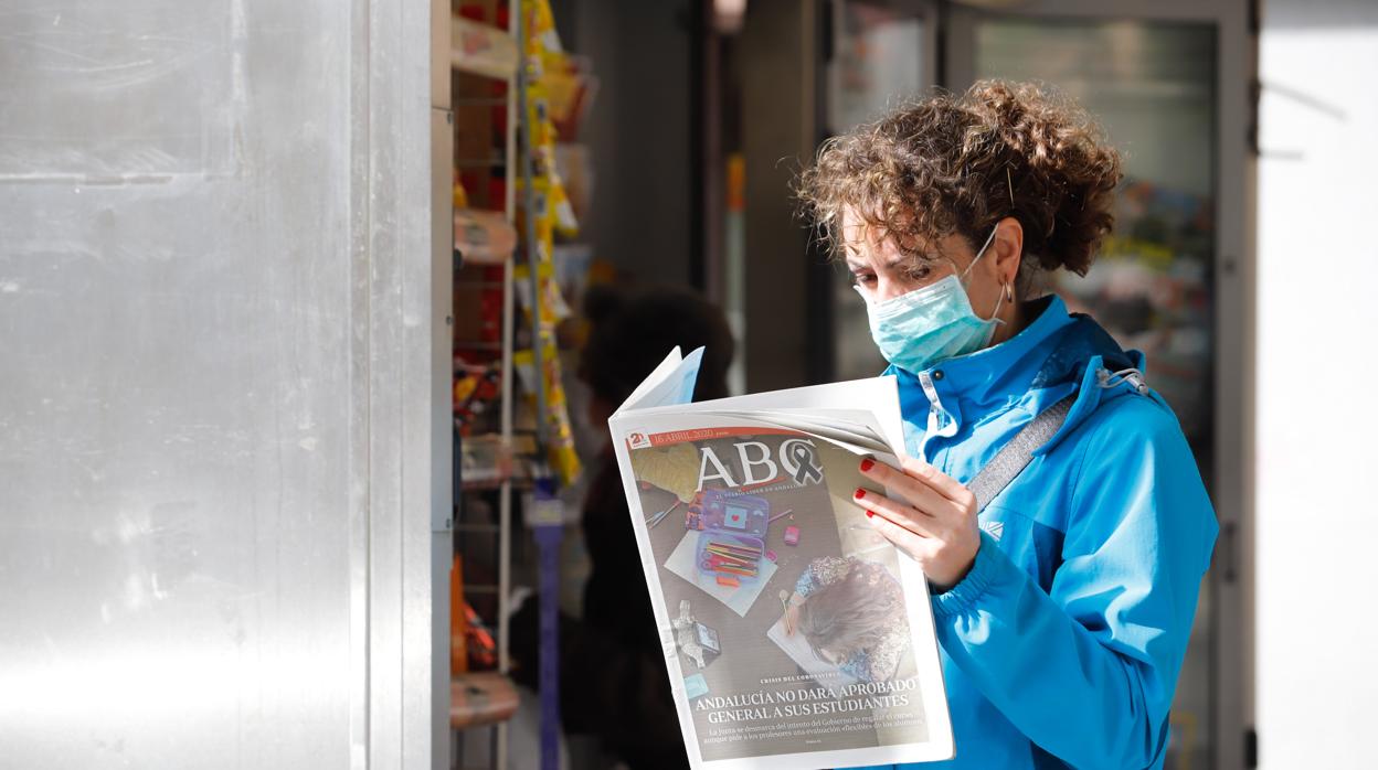 Una mujer lee un ejemplar de ABC Córdoba