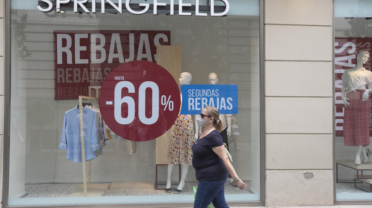 Una mujer pasa ante un establecimiento que anuncia sus rebajas en Córdoba