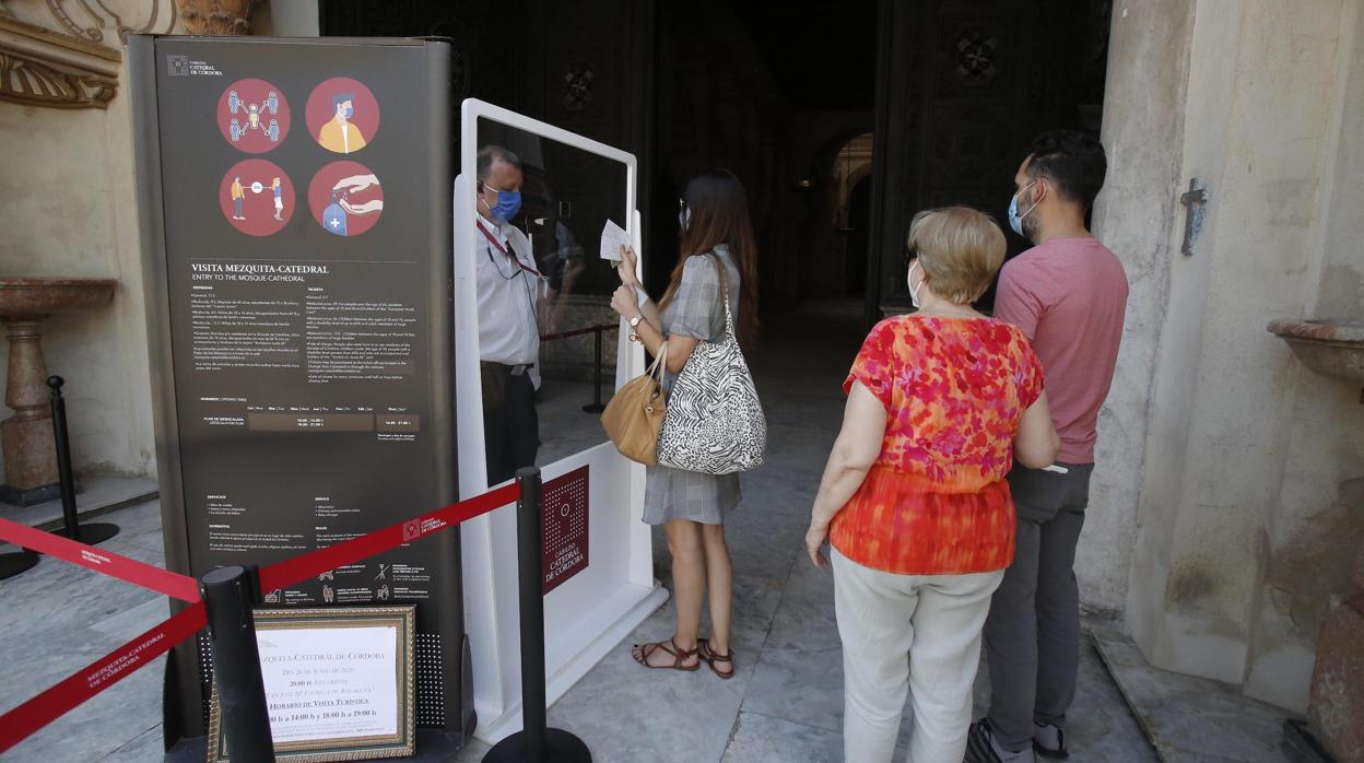 Tres turistas se disponen a entrar a la Mezquita-Catedral de Córdoba tras su reapertura