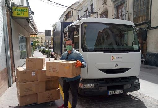 Un operario de Diputación con cajas de mascarillas en una población