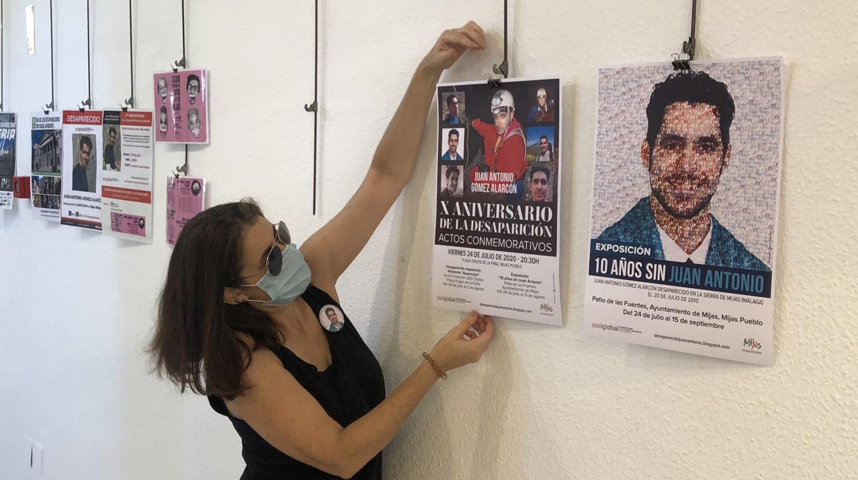 Ana María, hermana de Juan Antonio, coloca uno de los carteles de la búsqueda