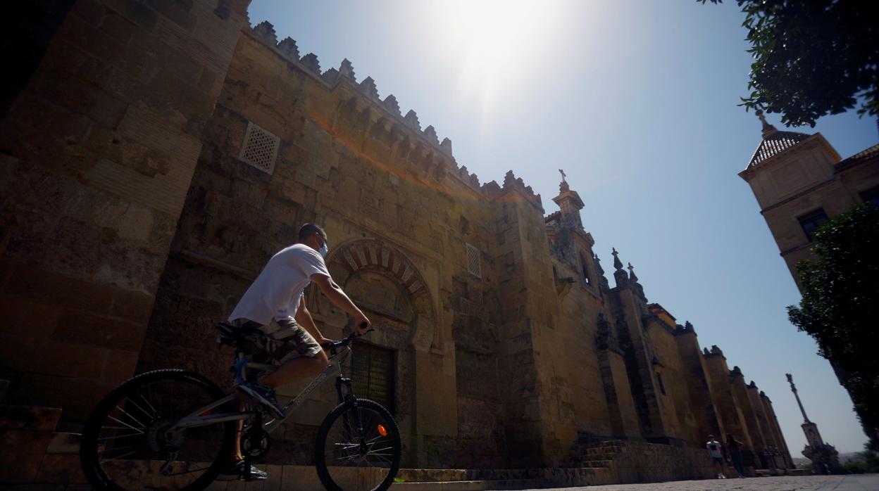 Un joven cruza la calle Torrijos de Córdoba junto a la Mezquita-Catedral este domingo a pleno sol