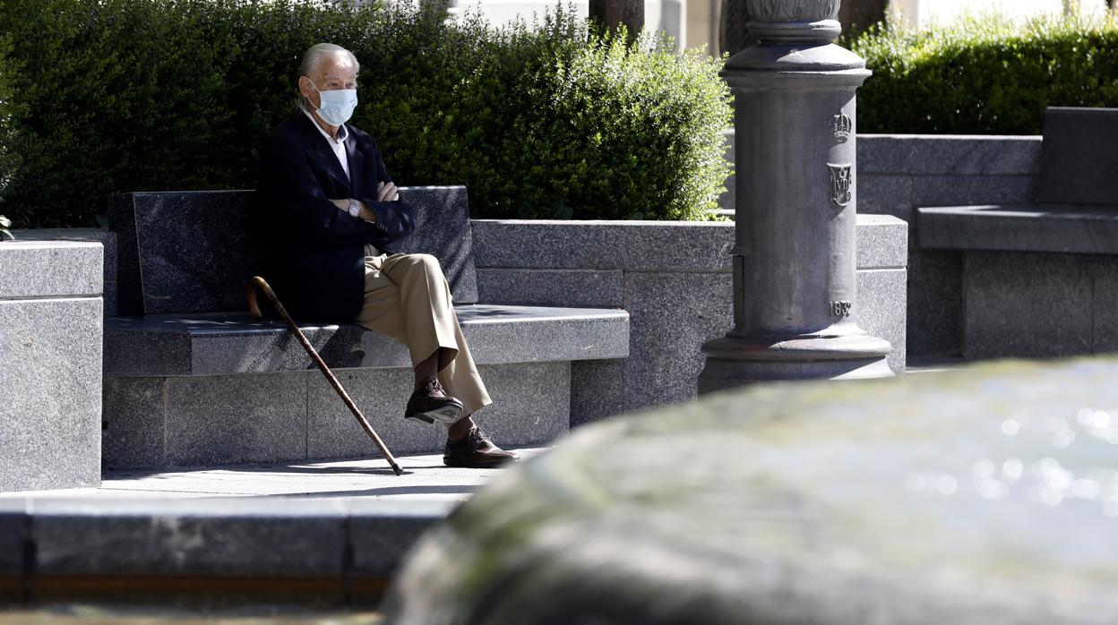 Un hombre mayor descansa solo en un banco de las Tendillas en el primer día de la desescalada