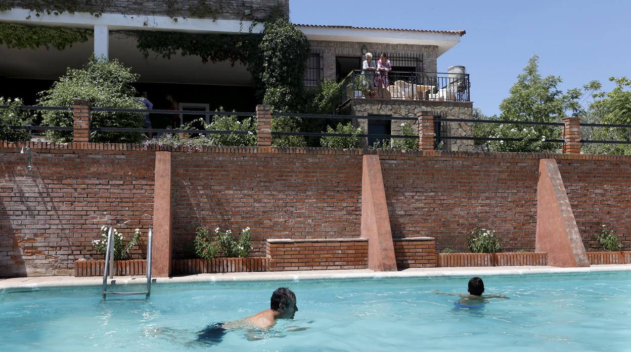 Una familia disfruta de la piscina en su chalet en Trassierra