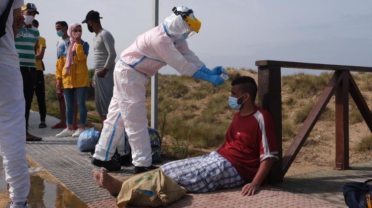 Un sanitario toma la temperatura a los inmigrantes llegados a Cádiz