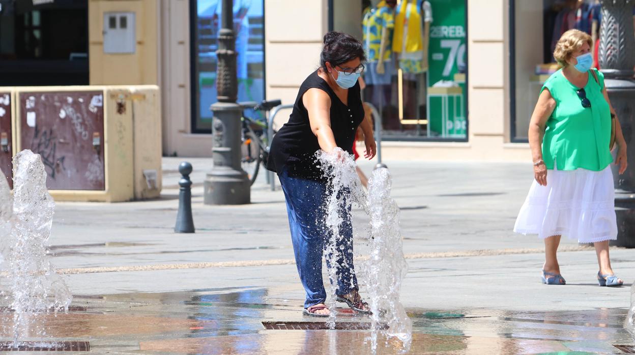 Una mujer se refresca en una fuente de Las Tendillas este agosto