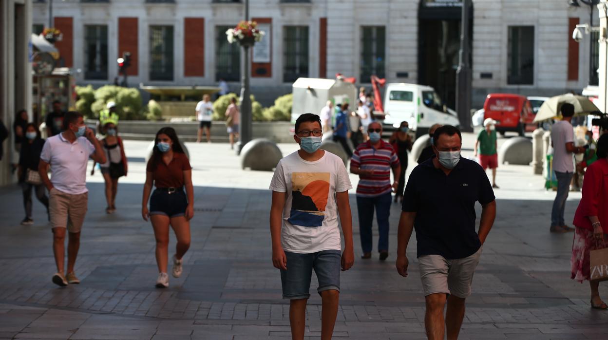 Viandates con mascarilla y distancia de seguridad pasean por una calle