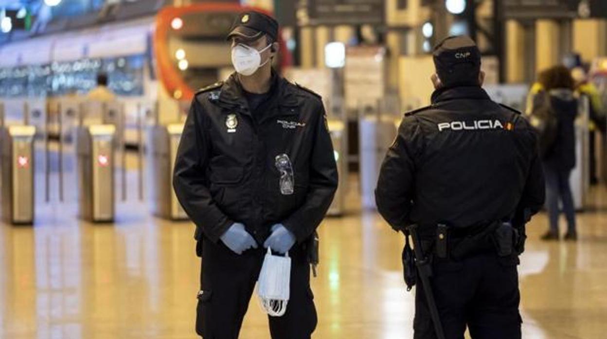 Policías con mascarilla en una estación de tren