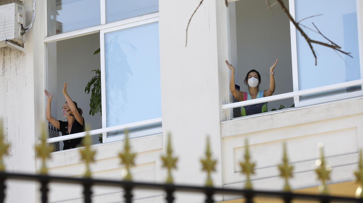 Dos profesoras del Colegio Colón saludan a los alumnos desde las ventanas