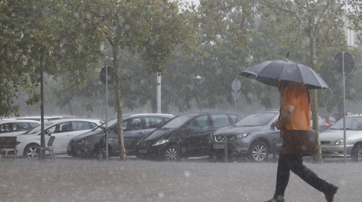 Un hombre se resguarda de la lluvia en la mañana de hoy