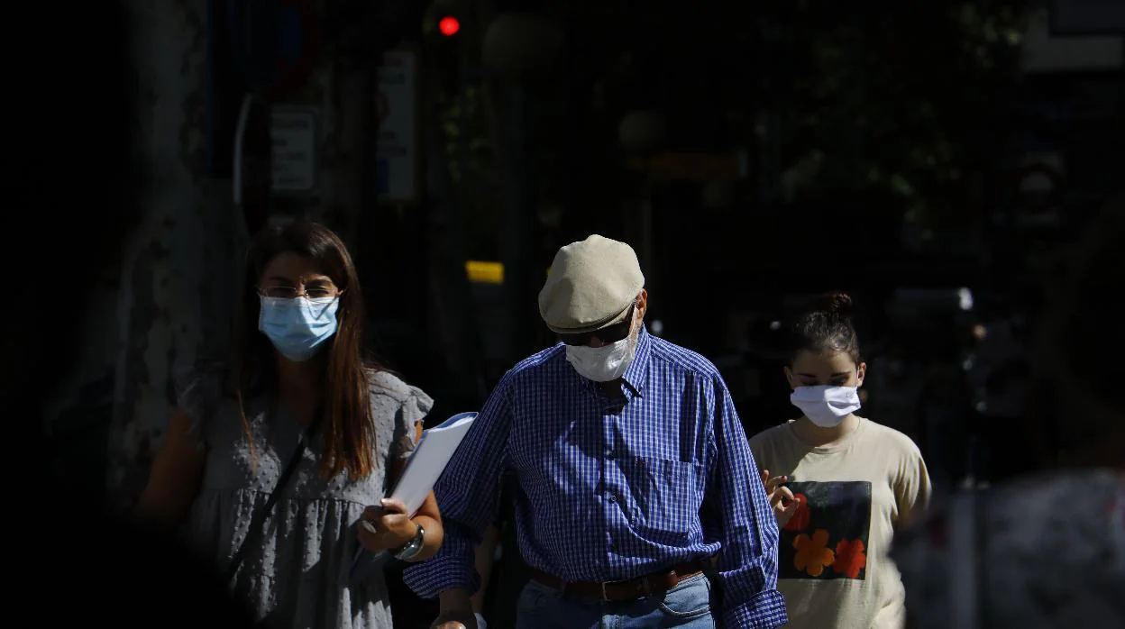 Personas con mascarillas pasean por una calle de Córdoba