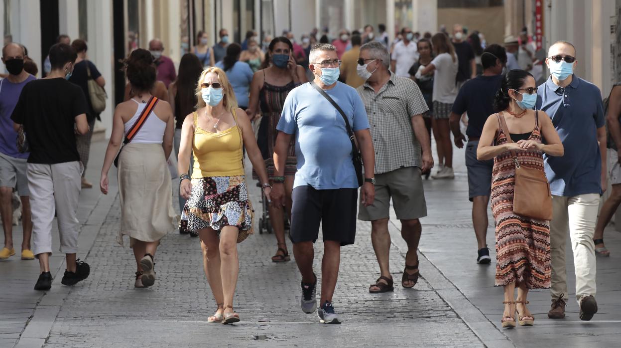 Transeúntes con mascarilla en el centro de Sevilla