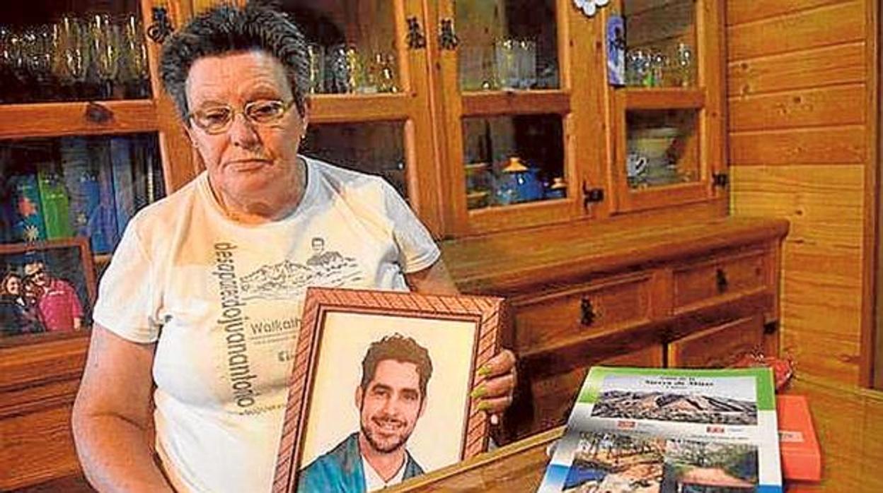 Ana Alarcón, madre de Juan Antonio con su retrato tras su desparición en 2010