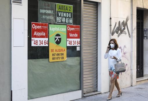 Un local vacío del Centro, cuyo escaparate está lleno de carteles comercializándolo