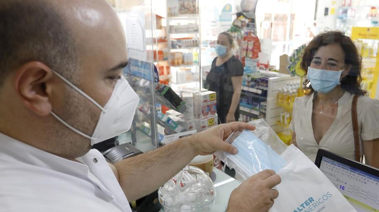 Una mujer compra una mascarilla en una farmacia de Córdoba