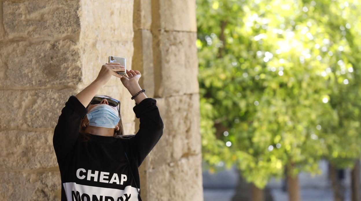 Una joven hace una foto en el Patio de los Naranjos de la Mezquita-Catedral