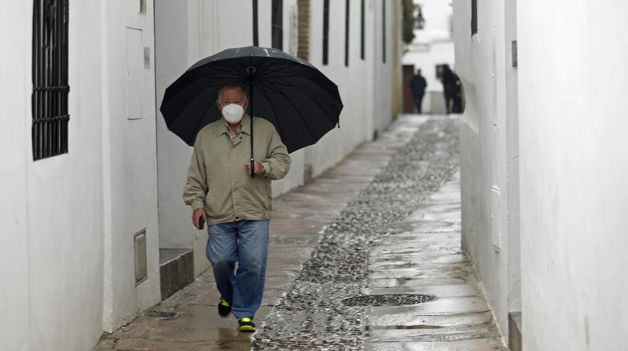 Un hombre pasea por el Casco de Córdoba bajo la lluvia