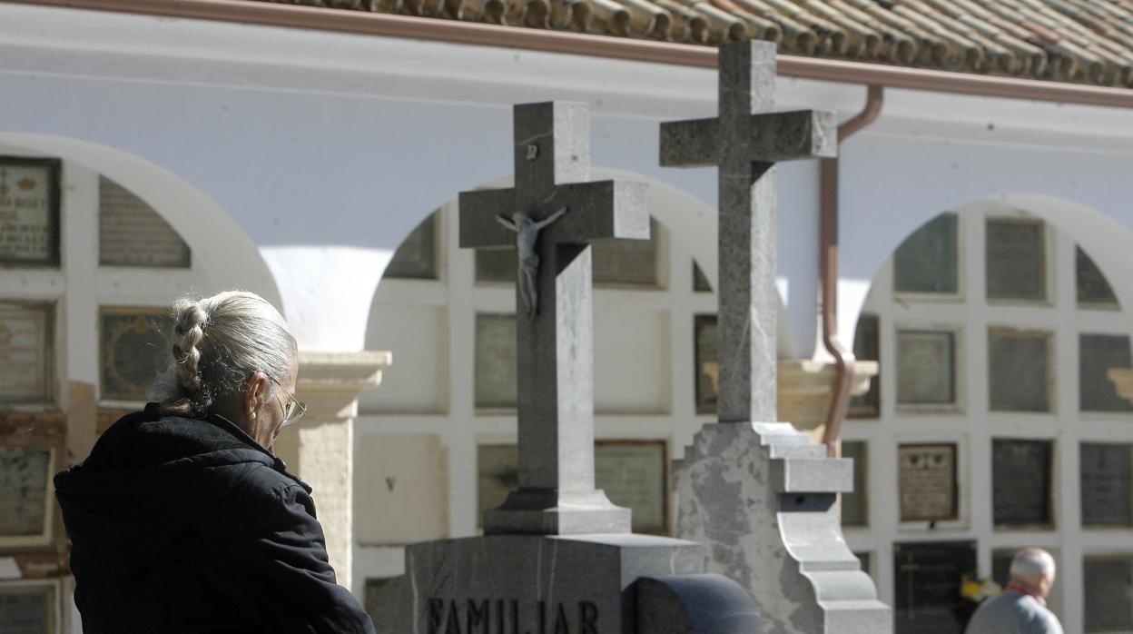 Una mujer delante de una sepultura